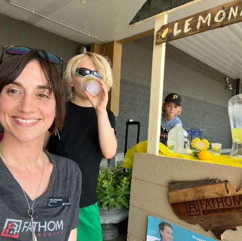Fathom Realty Agents serving Lemonade to raise charity funds and wearing Fathom Realty shirts